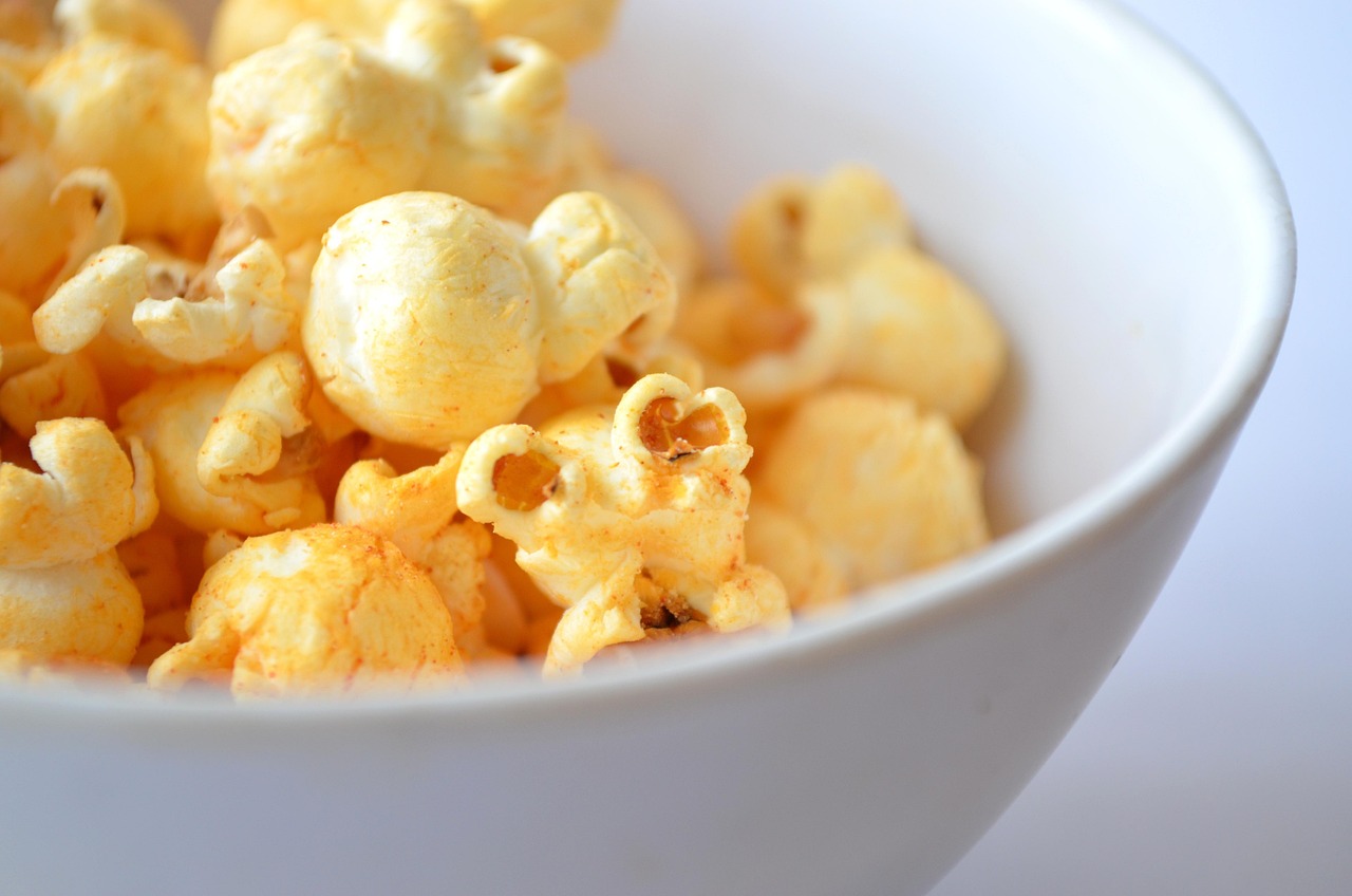 Popcorn aromatizzati con spezie e burro fuso in una ciotola colorata.