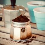 Fondi di caffè in un contenitore, pronti per essere usati come detergente per pentole incrostate.