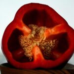 Peperoni freschi tagliati, evidenziando la rimozione di semi e filamenti bianchi per una migliore digeribilità.